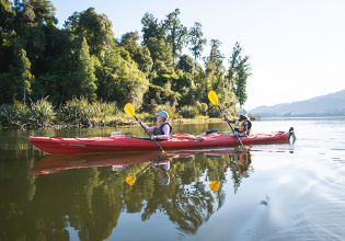 Kayaking across Lake Mapourika in a tandem kayak